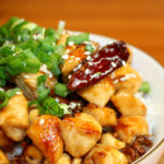 Eine Schale mit Gongbao Jiding. Das Gericht ist garniert mit Frühlingszwiebeln.