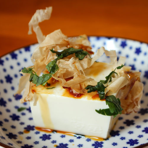 Kaltes Tofu Rezept: Ein Block kaltes Tofu garniert mit Katsuoboshi-Flocken, Shiso-Blättern und geriebenem Ingwer.