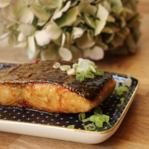 Lachs angerichtet auf einem Teller auf einem Holztisch